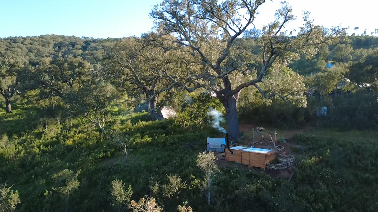 The wood-fired tub under the old cork oak.